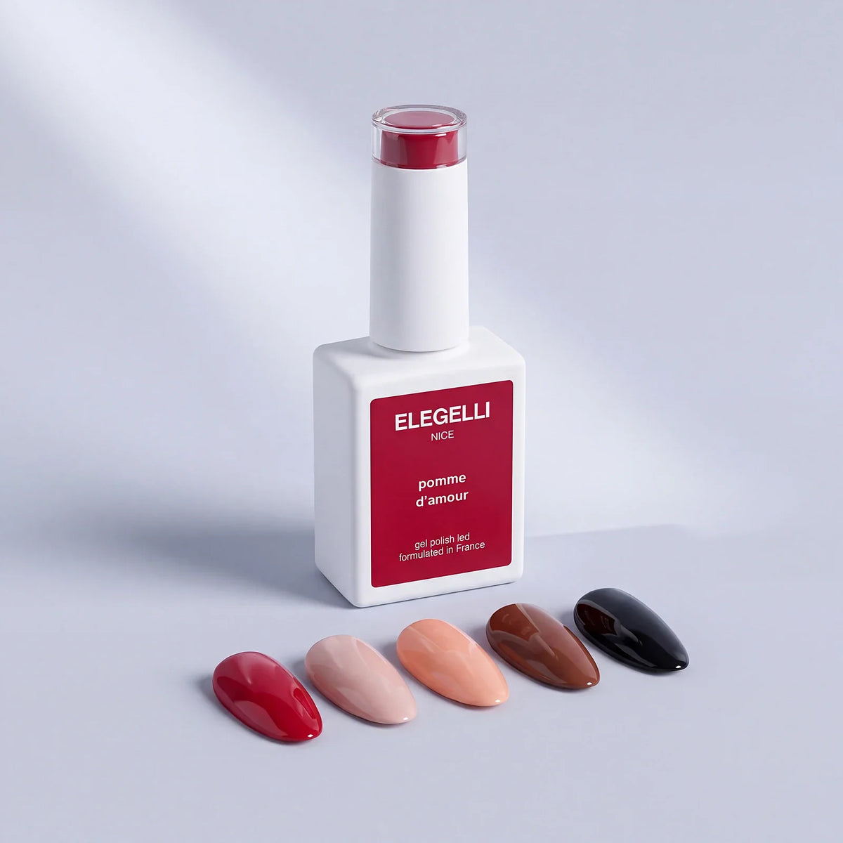 Elegelli Pomme d'Amour red gel polish bottle with five glossy gel nail tips in red, nude, peach, chestnut and black