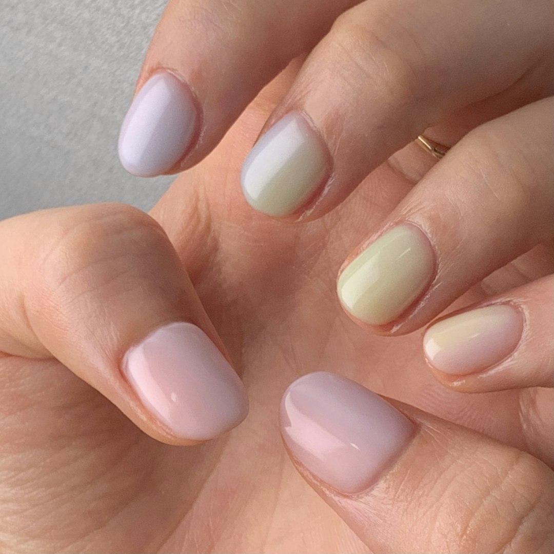 Short glossy nails in soft pastel lilac, sage, butter yellow and pink