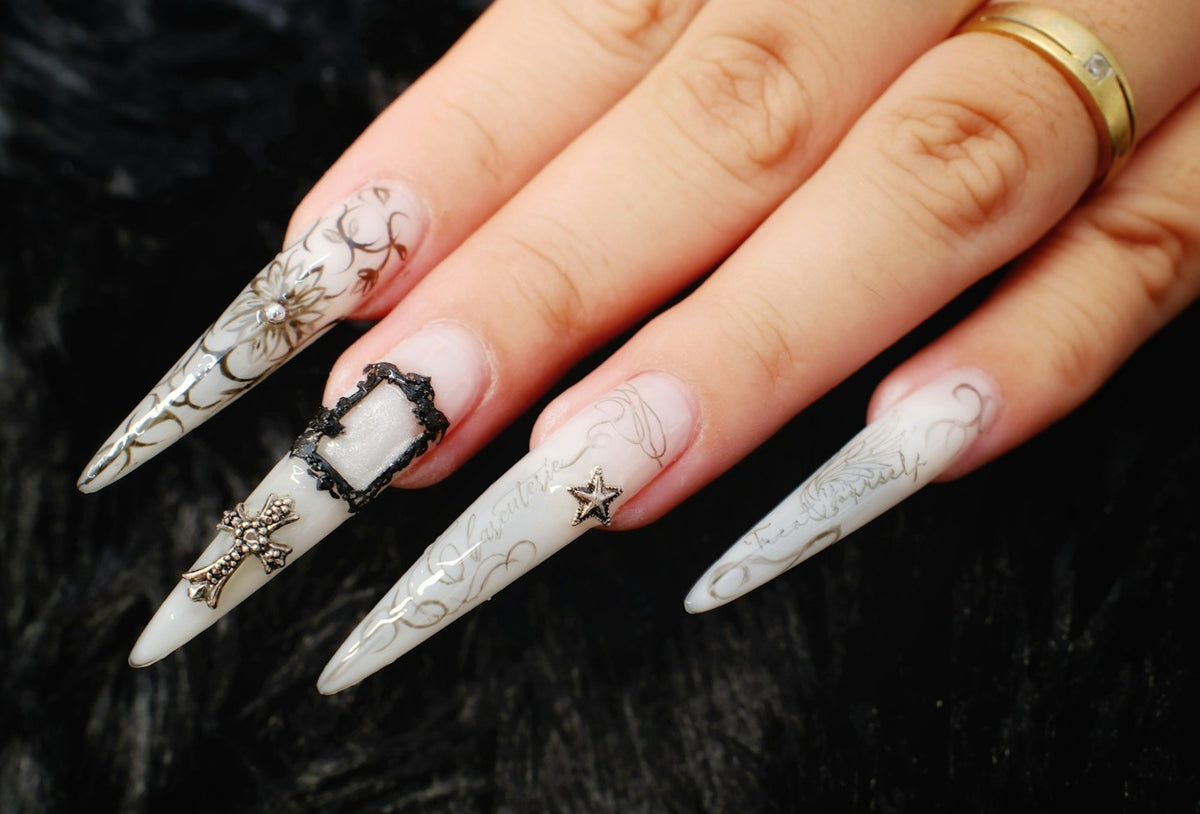 Long white stiletto nails with raised silver 3D details on black fur