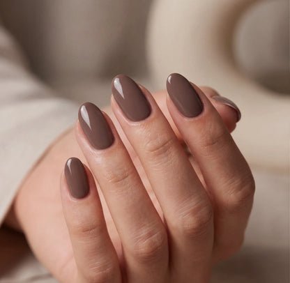 Close-up of a hand with brown nail polish on a blurred background