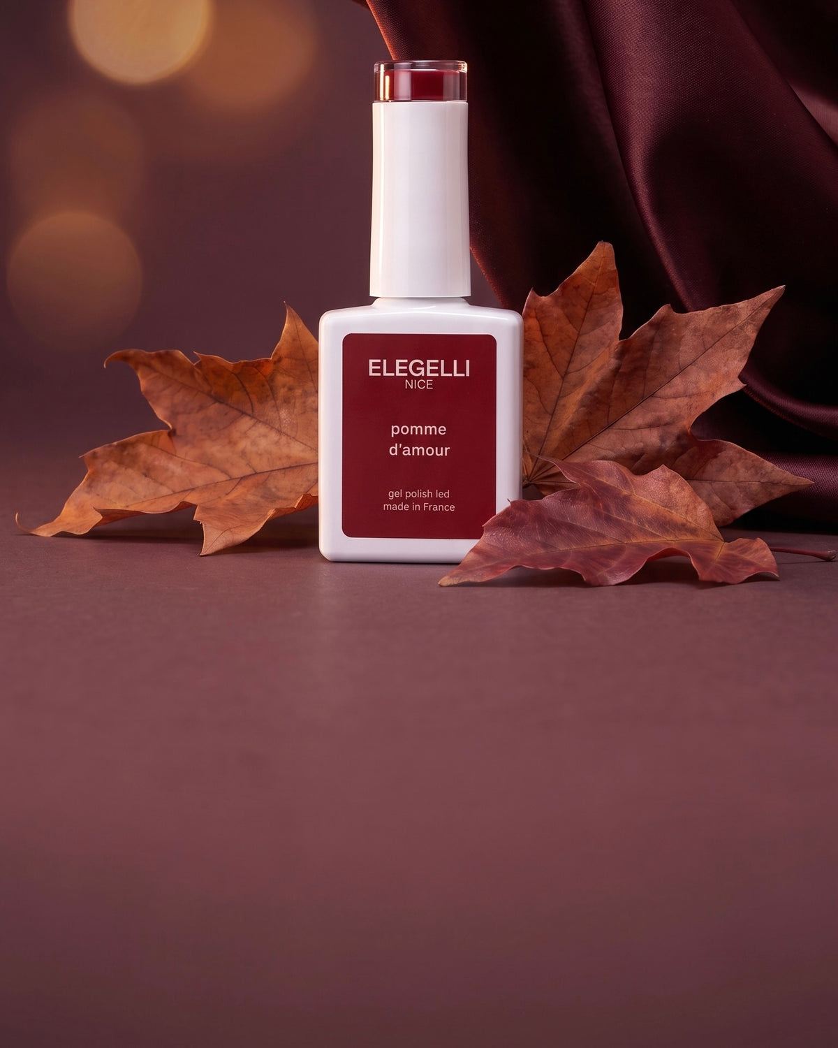 Флакон гель-лака Elegelli среди осенних листьев